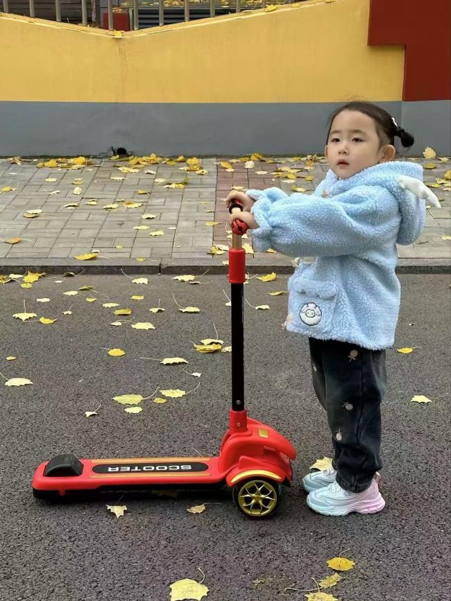 秋日童趣：蓝绒女孩骑红滑板车落叶满径瞬间