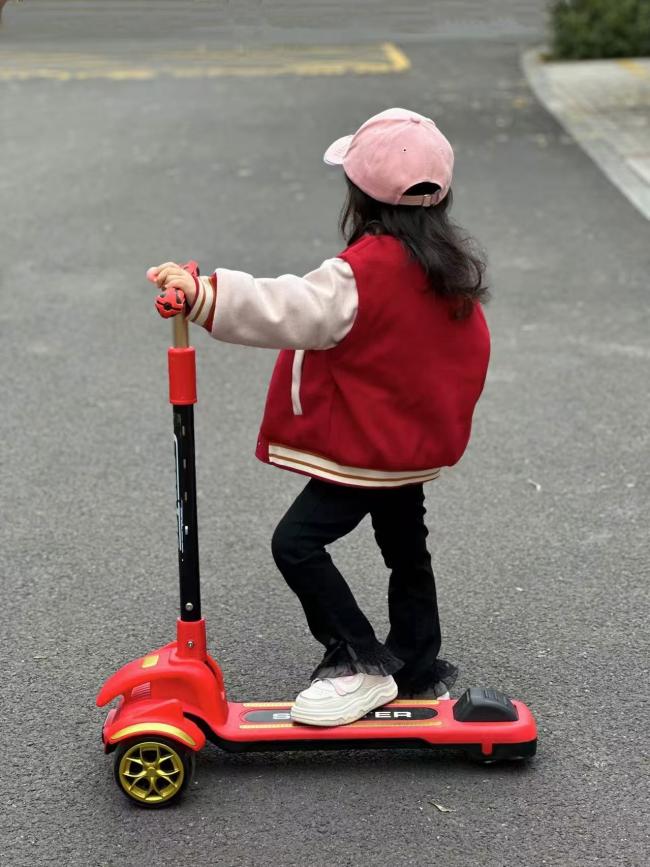 粉帽红衣小女孩骑红色滑板车背影照